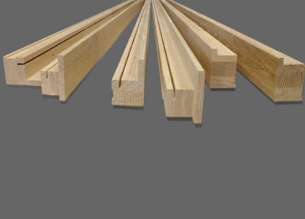 Five unfinished wooden mouldings with various profiles are displayed on grey, showing cross-sections and shapes ideal for ECLISSE Pocket Door System - Classic Double Fire-Rated installations.