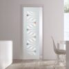 A modern, minimalistic room features ECLISSE Pocket Door Systems - Classic Single Glass Doors 10mm Plain or Patterned with wavy white patterns and colourful accents. A nearby white table with chairs is set beside a sideboard decorated with vases and fruit.
