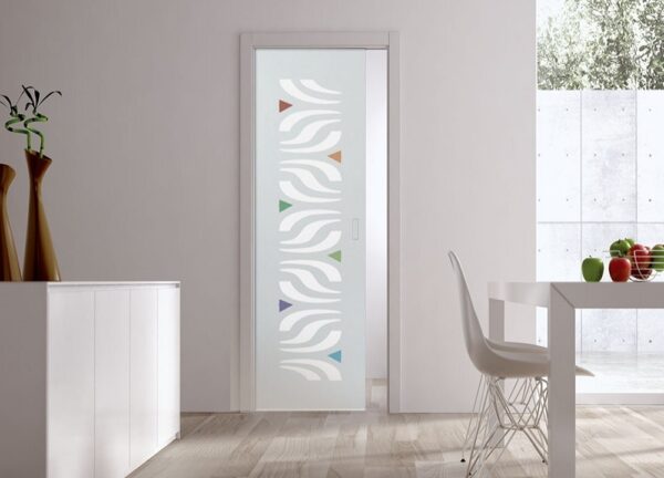 A modern, minimalistic room features ECLISSE Pocket Door Systems - Classic Single Glass Doors 10mm Plain or Patterned with wavy white patterns and colourful accents. A nearby white table with chairs is set beside a sideboard decorated with vases and fruit.