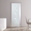 An ECLISSE Pocket Door System – Classic Single Glass Doors 10mm with a frosted circle pattern separates a modern white cupboard from a dining table with white chairs in a bright, minimalistic room.