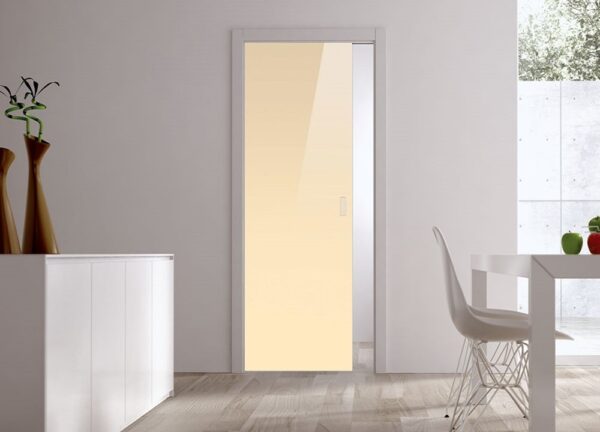 A modern, minimalistic room features an ECLISSE Pocket Door Systems - Classic Single Glass Doors 10mm (plain), white walls, wooden floor, a white sideboard with vases, and a white dining table with chair by a large window.