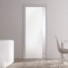 A modern, minimalist room with an ECLISSE Pocket Door System – Classic Single Glass Plain Satin 8mm, a sleek white cupboard topped with two tall vases, and a dining table with a wire chair. Natural light fills the space through a large window.