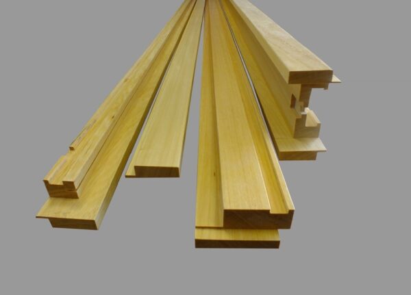 Several pieces from the ECLISSE Classic Fire-Rated Pocket Door Kit – Single, featuring light-coloured wooden trim ideal for finishing pocket or sliding doors, are displayed side by side on a grey background.