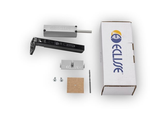 A Touch Latch for Syntesis® Flush pocket door system kit is shown on a white background, with a white ECLISSE box, two metal parts, a black bracket, screws, a small brown square, and a drill bit—all neatly arranged for sliding doors.