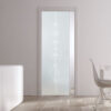 A modern interior showcases ECLISSE Pocket Door Systems—Classic Single Glass Doors 10mm (plain or patterned), frosted with geometric designs, light wood floors, a white cupboard with tall vases, and a white dining table with a wire chair by a large window.