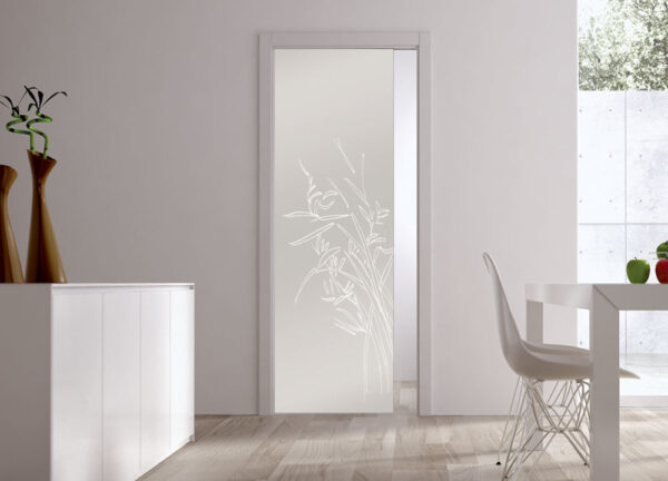 A modern dining area features an ECLISSE Pocket Door Systems - Classic Single Glass Doors 10mm Plain or Patterned. White furniture, wooden flooring, and natural light from a large window complete the elegant, minimalistic space.
