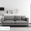 A modern living room with a grey sofa, white décor shelves, and a dark doorway featuring the Rocket Door Frames - 90mm Pocket Door Kit. The Rocket Door Frames logo is visible in the bottom left corner, with a glimpse of a bathroom beyond.