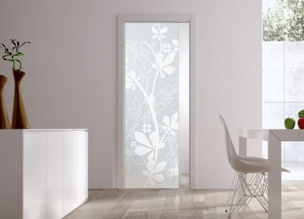 A modern room with light wood flooring features ECLISSE Pocket Door Systems Classic Single Glass Doors (10mm, plain or patterned). A white cabinet with two tall brown vases and a sleek white dining table with matching chair complete the look.
