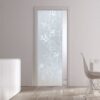 A modern, minimal living space features an ECLISSE Pocket Door System with a 10mm patterned glass door, white furniture, and wooden flooring. Sunlight streams in from a large right-side window.