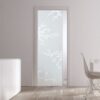 A modern room with light wood floors, a white sideboard, two brown vases, a white table and chair, and an ECLISSE Pocket Door Systems - Classic Single Glass Doors 10mm Plain or Patterned leading to a bright outdoor space.