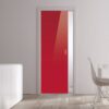 A modern interior with an ECLISSE Pocket Door Systems Classic Single Glass Door (10mm plain) in glossy red set in a white wall, light wooden floor, a white cabinet with vases on the left, and part of a white dining table and chair on the right.
