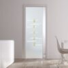 A modern interior with ECLISSE Pocket Door Systems Classic Single Glass Doors (10mm, patterned glass), white walls, light wood floors, a white cabinet, and a white dining table with a wire-frame chair.