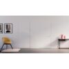 Minimalist room with ULTRA Flush Hinged Rocket Door Frames, a yellow chair on a pink rug, two abstract black-and-white wall prints, and a black console table decorated with pink and white accents.
