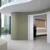 Modern office lobby with curved walls and Eclisse Pocket Door System - CURVED DOUBLE, recessed ceiling lights, large glass windows, and pocket doors leading to a bright reception area with wood panelling and indoor plants.