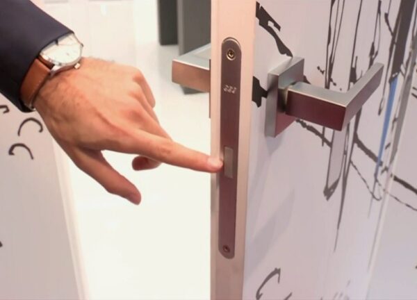 A person uses a fingerprint scanner built into the handle, showcasing biometric access on the sleek ECLISSE Door system - Syntesis® Hinged Single With Door.