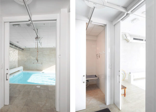 Side-by-side images feature a bright indoor pool area with a ceiling hoist and a modern shower room with fold-down seat, divided by the Classic Hoist Pocket Door System. White walls throughout create a clean, open look.