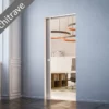 An ECLISSE Pocket Door System - Syntesis® Single, shown partially open with no architrave, reveals an office space with a desk, shelves, and circular ceiling lights. A grey banner in the corner says “No architrave.”.