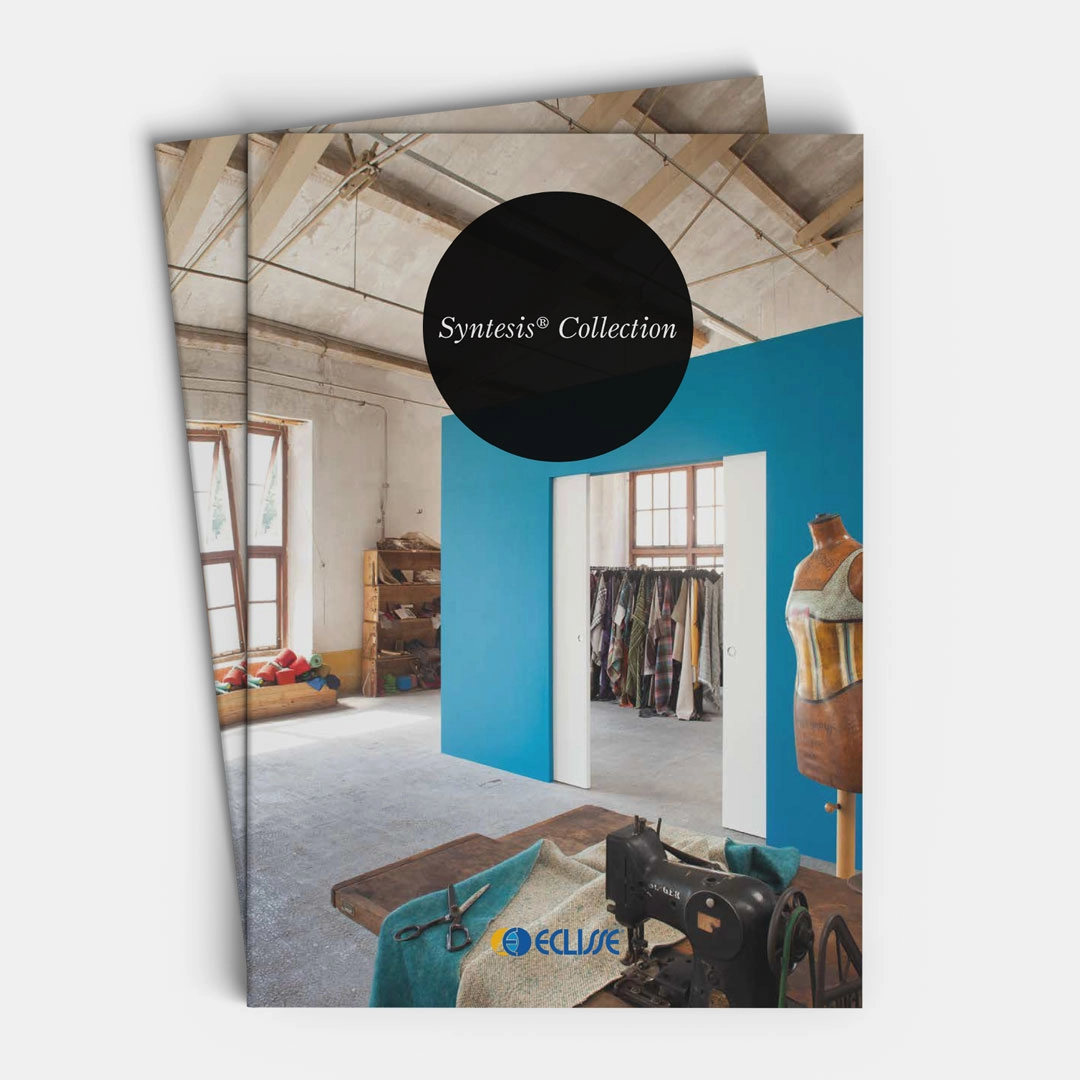 A catalogue titled Syntesis® Collection with a cover image showing a bright studio space, blue wall partition with ECLISSE sliding doors, mannequins, clothes rail, vintage sewing machine, and natural light from large windows.