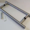 The Eclisse Pull Bar Handle - Back to Back for timber and glass doors includes two parallel stainless steel handles with black washers, an Allen key, and two screws—perfect for pocket or sliding door installation.